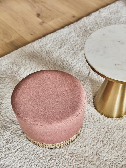 rotan roze poef naast chique marmeren bijzettafel
