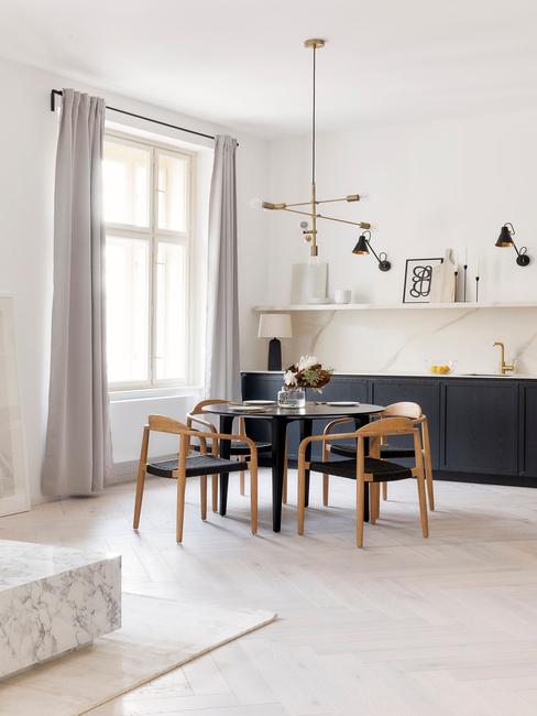 woonkamer met ronde eettafel en houten stoelen