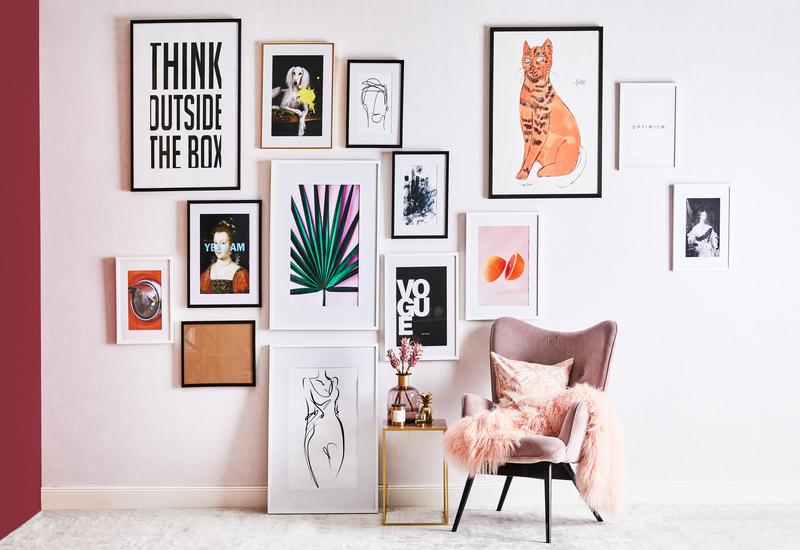 fotolijsten op roze muur met roze stoel en zachte roze deken
