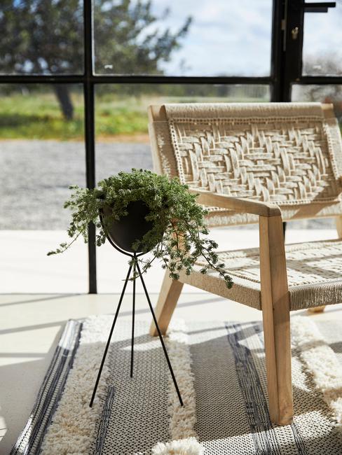 plantenpot op poten naast houten stoel