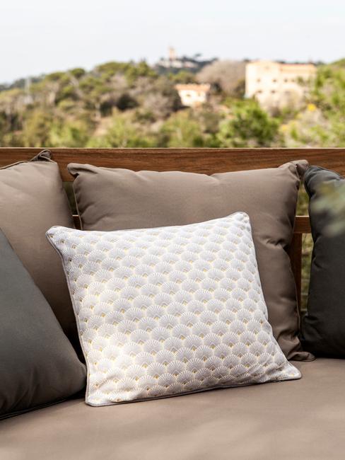 beige en witte kussens op een outdoor bank