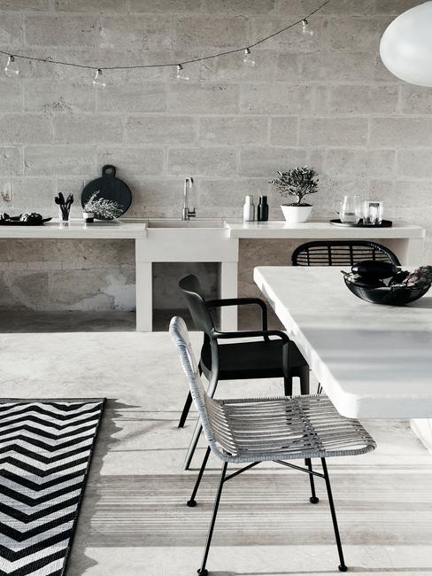 witte tafel met zwarte en witte tuinstoelen in een moderne tuin
