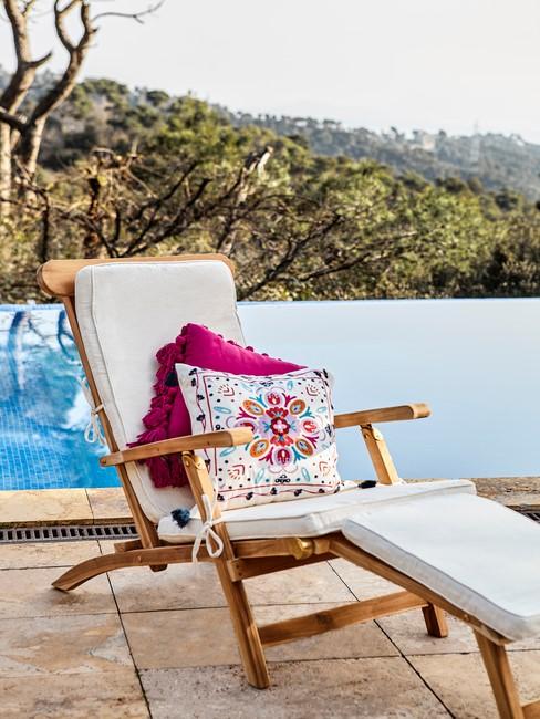 houten ligstoel met witte en gekleurde kussens