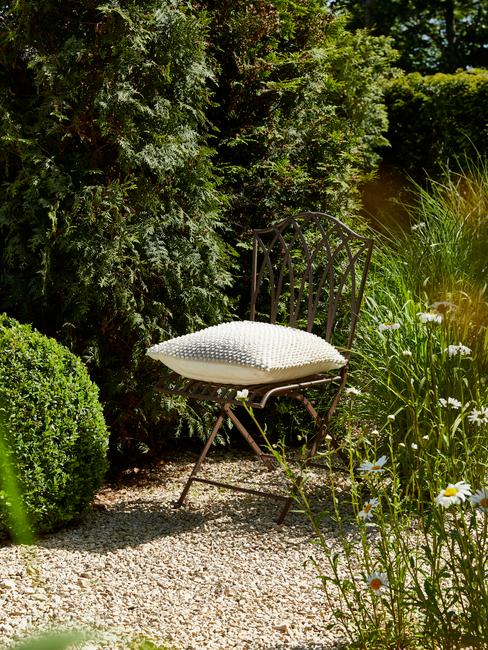 stoel met wit kussen in een tuin