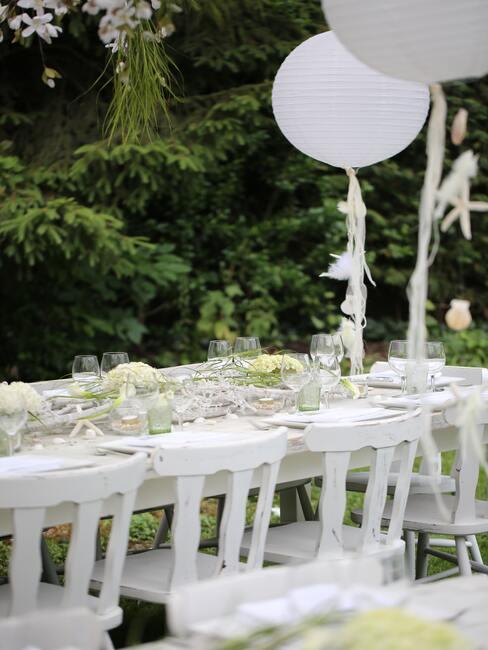 tafel gedekt voor een bruiloft met witte ballonnen