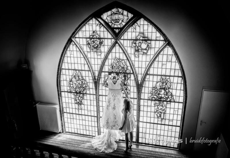 bruidsfoto in kerk voor glas in lood raam