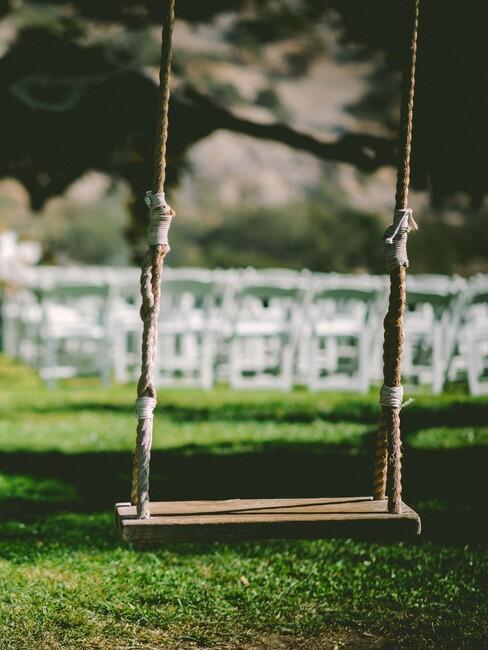 witte stoelen met een houten schommel