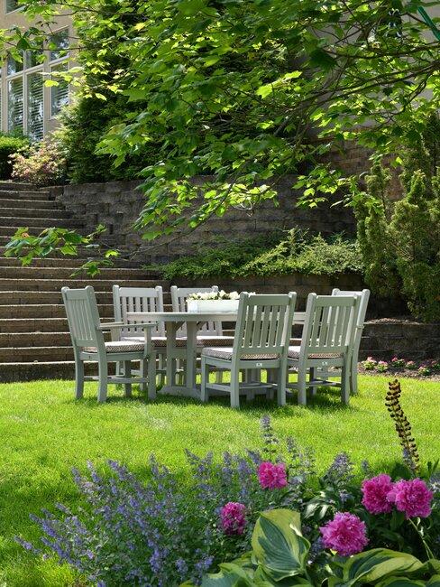verticuteren_1 tuin met gras en een witte eettafel met stoelen