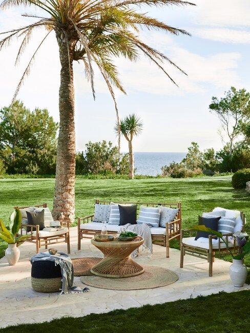 tuin met gras en loungeset en palmbomen