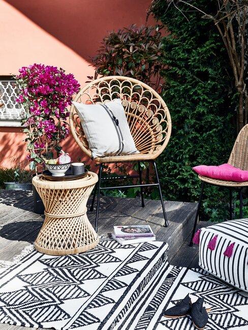 tuin met vloerkleed en rieten stoel