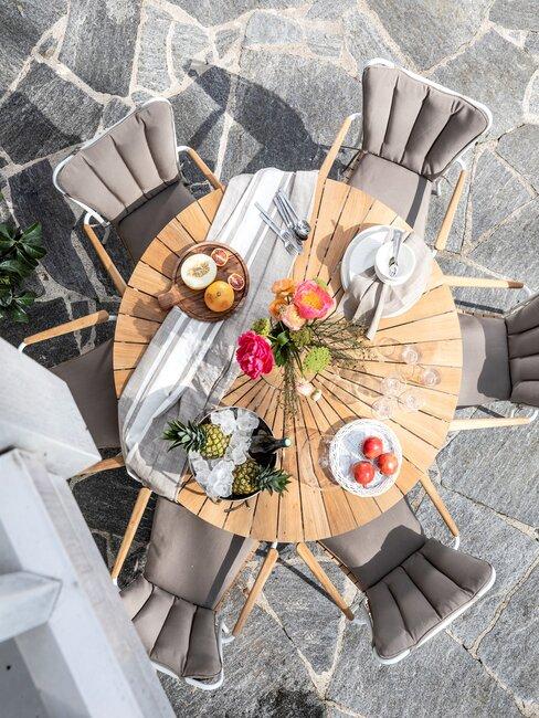 terras met grijze stenen en houten tafel
