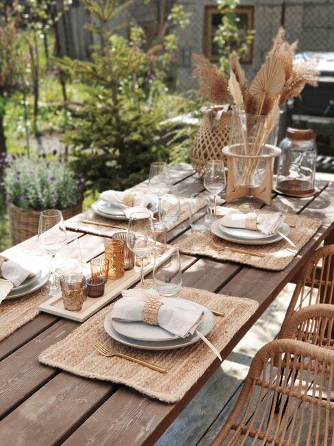 houten buitentafel gedekt met rieten placemats