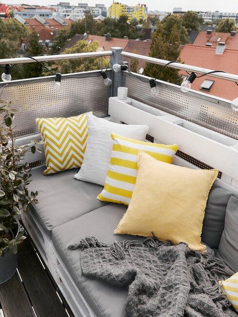 balkon met loungebank en gele kussens