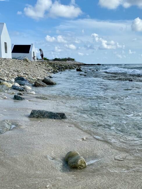 huisjes aan het water met een strand en rotsen