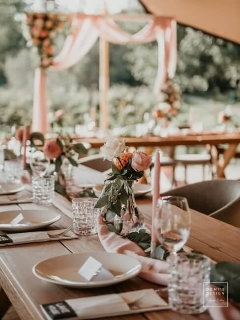 Tafeldecoratie met roze rozen overdekt door tent
