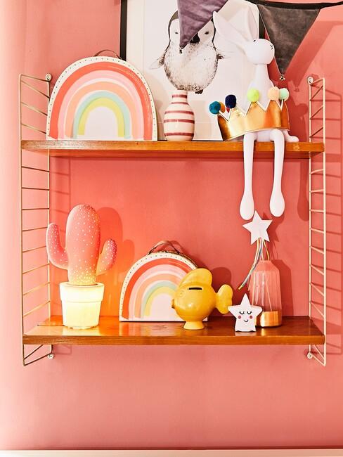 plankjes met speelgoed op oranje muur