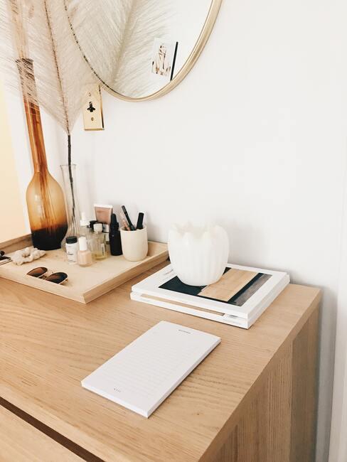 houten bureau met een boek en sieraden