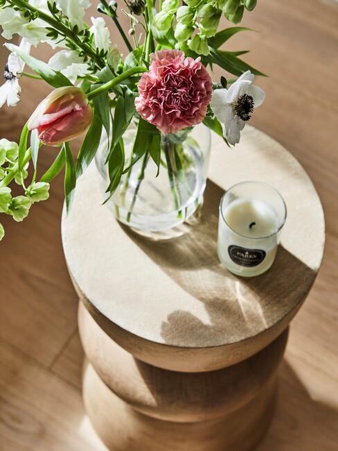 houten bijzettafel met bloemen en witte kaars