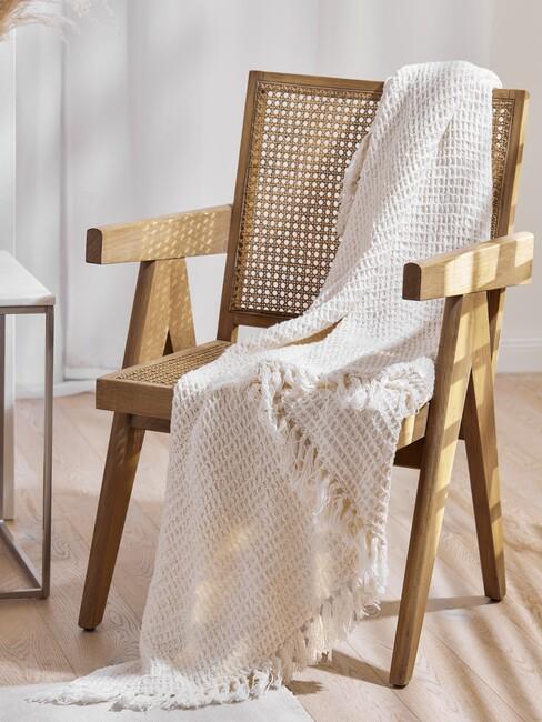 houten stoel met beige deken