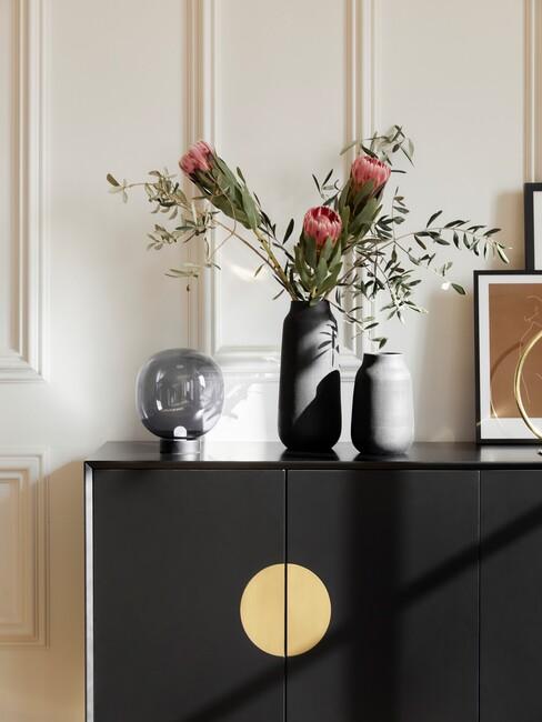 herfstbloemen in vaas op zwart dressoir