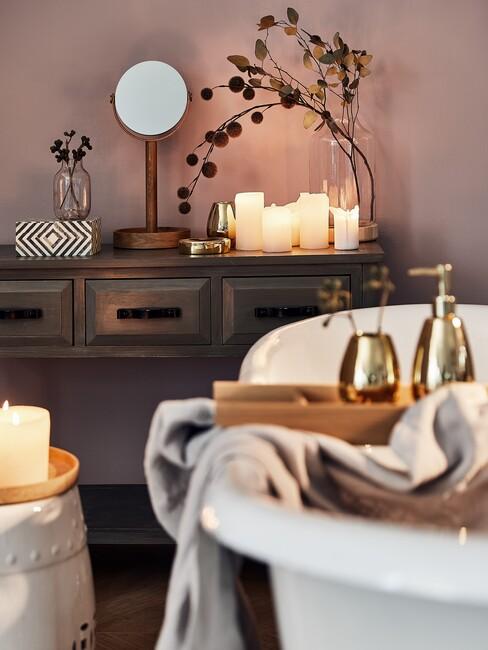 witte badkuip met een houten kast en een gouden spiegel