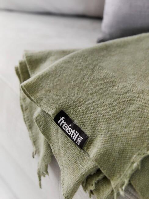 olijfgroen: plaid op een grijze bank