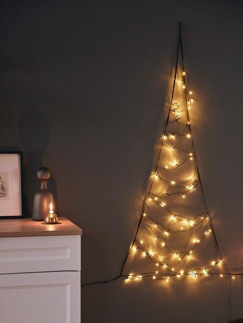 kersttrends-2021: lampjes kerstboom tegen een muur