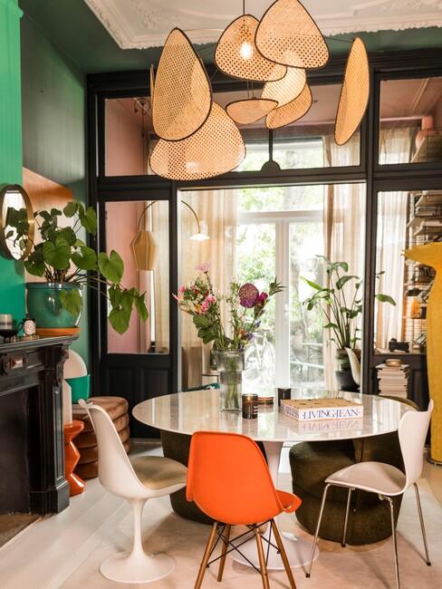 pannenkoekenplant: op donkere gevel met ronde witte tafel en oranje stoel