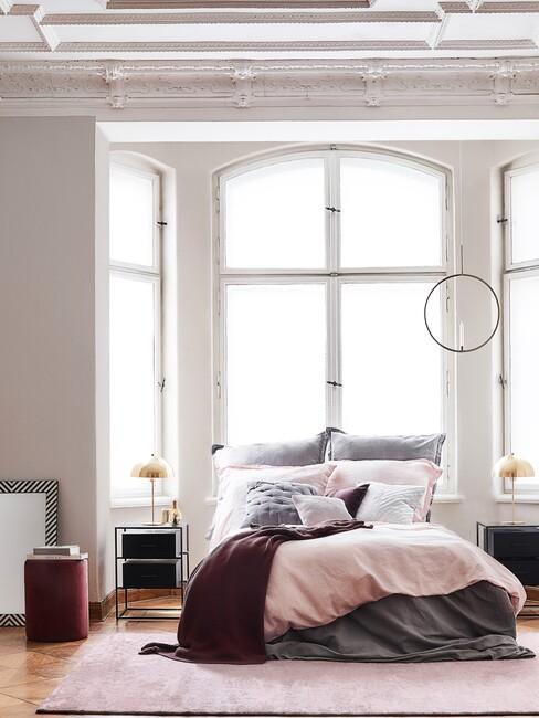 bed met roze en paarsen deken