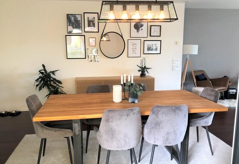 Gezellige woonkamer met houten tafel en grote hanglamp