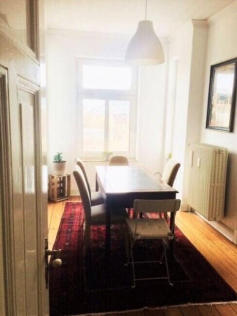 woonkamer met eettafel en grote kast