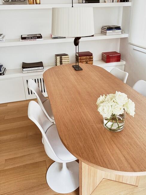 Houten ovale eettafel met ronde witte stoelen