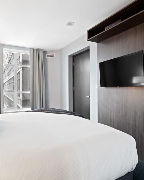 decoratie slaapkamer muur met een wit dekbed en tv