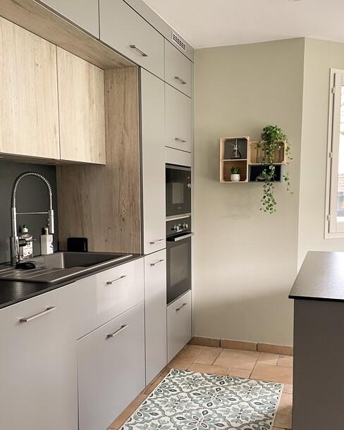 Grijze keuken met houten kasten en zwart blad