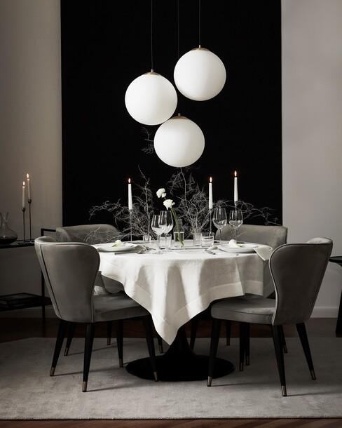 Ronde tafel met groene stoelen en ronde hanglampen