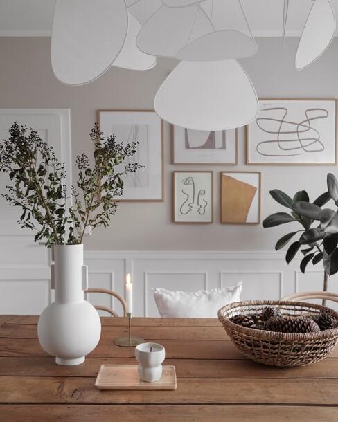 Witte lamp boven eettafel en witte vaas