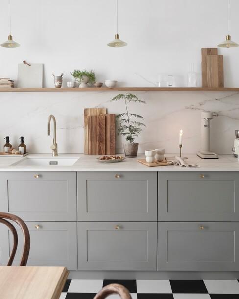 keuken inrichten met een grijze keuken met houten plank en gouden wandlampen