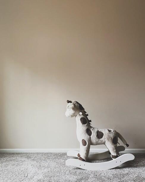 muurschildering babykamer met beige en een hobbel paard