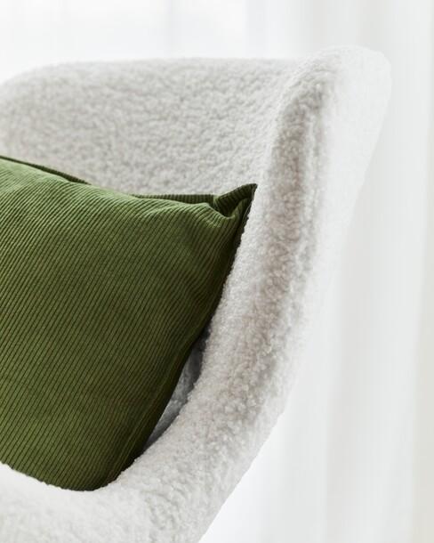 close up van teddy stoel met groen kussen