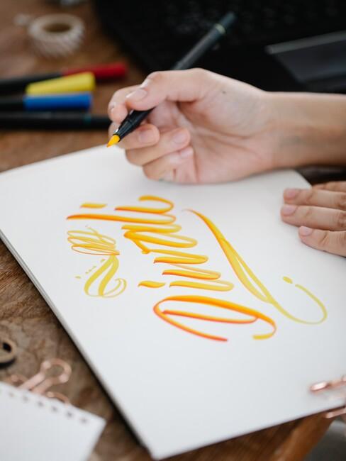 kalligrafie met een gele stift op wit papier