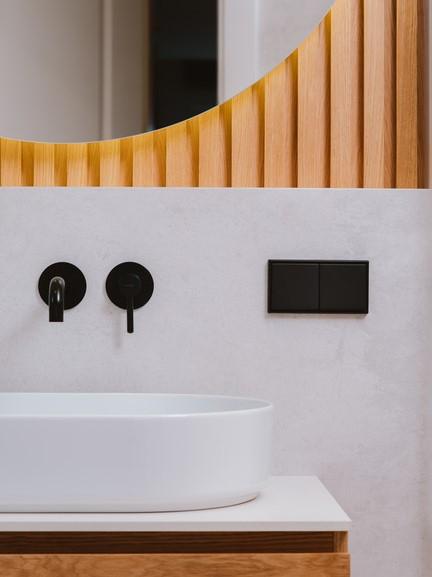hout op de muur met witte wasbak en zwarte kraan
