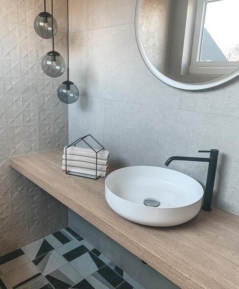 ronde witte wasbak op houten blad in toiletruimte