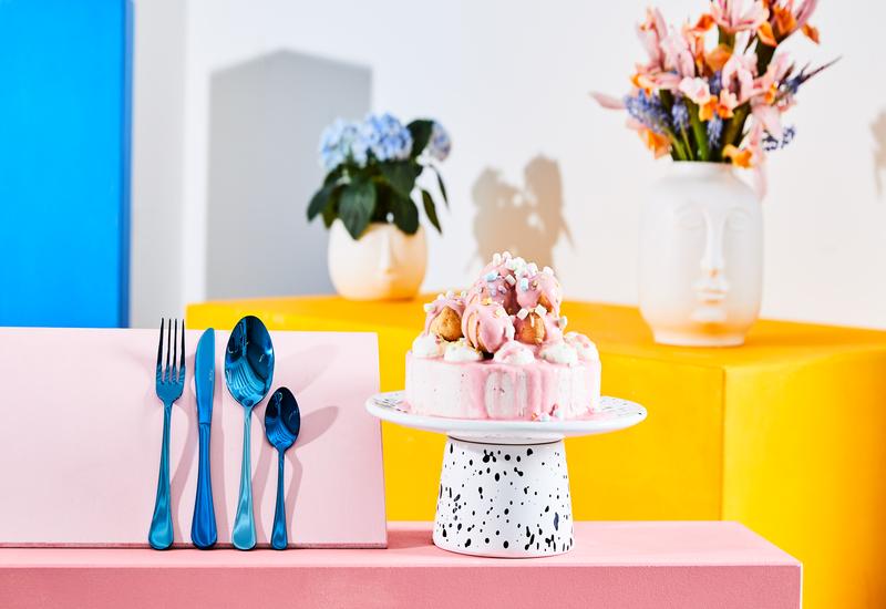 Gender reveal party met een roze taart en blauw bestek