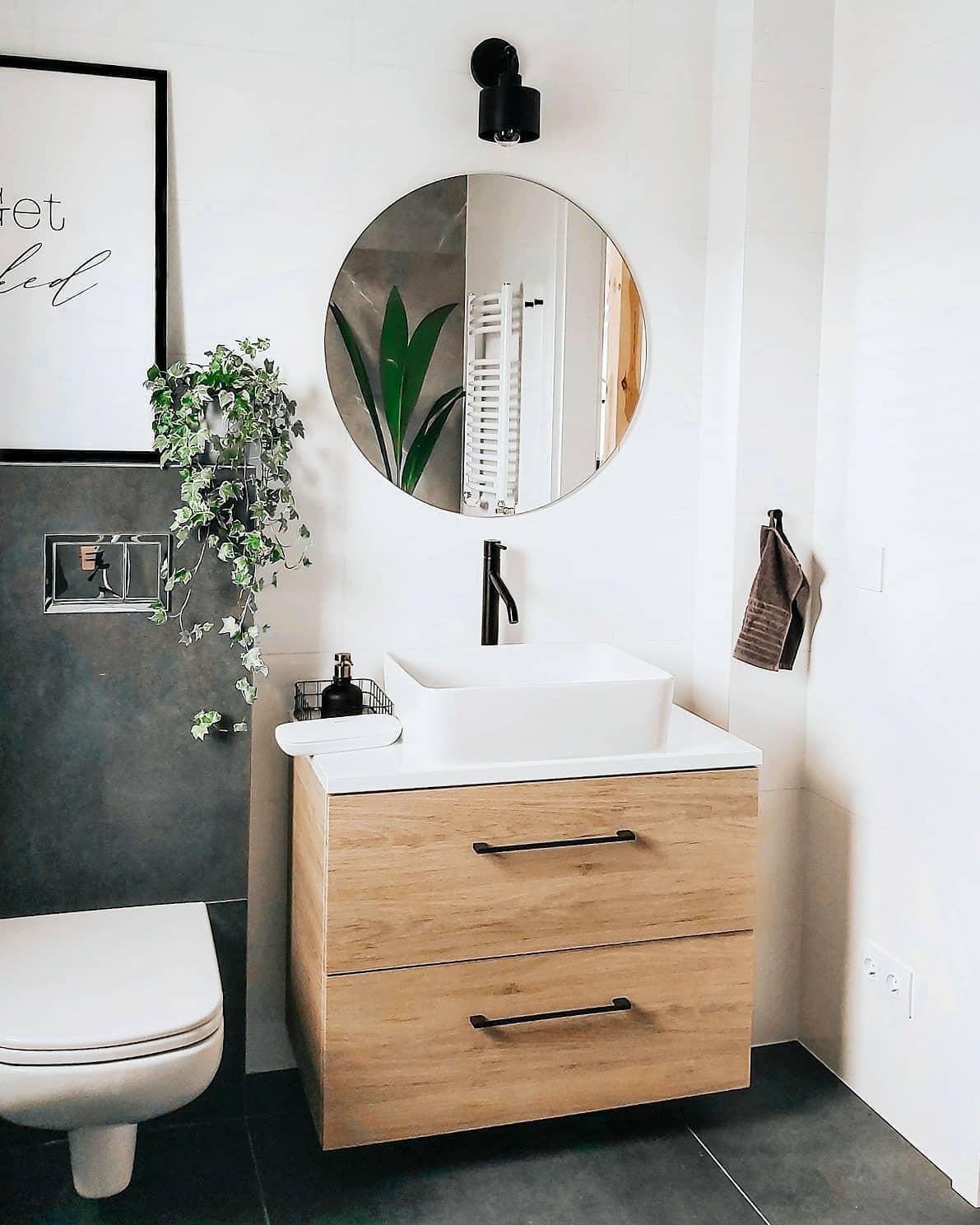 ronde spiegel boven houten kast in toilet