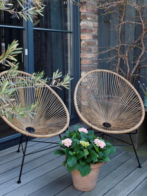 scandinavische tuin met ronde rotan stoelen