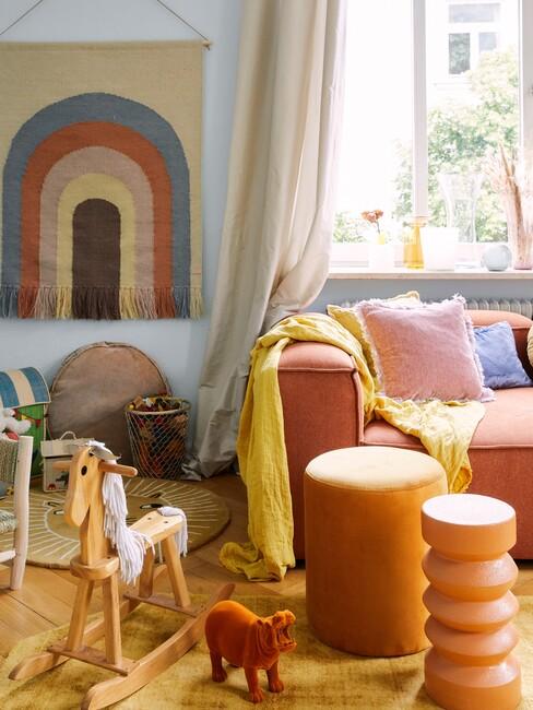 speelhoek in de woonkamer met regenboog wanddecoratie
