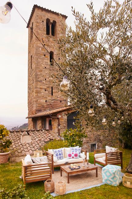 tuin met loungeset en oud gebouw