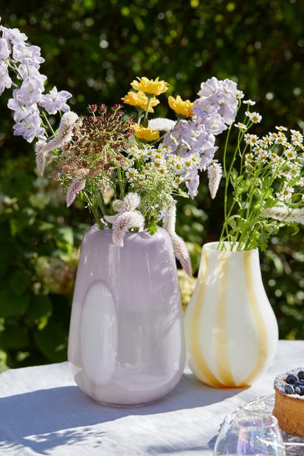 twee vazen op een tuintafel met bloemen