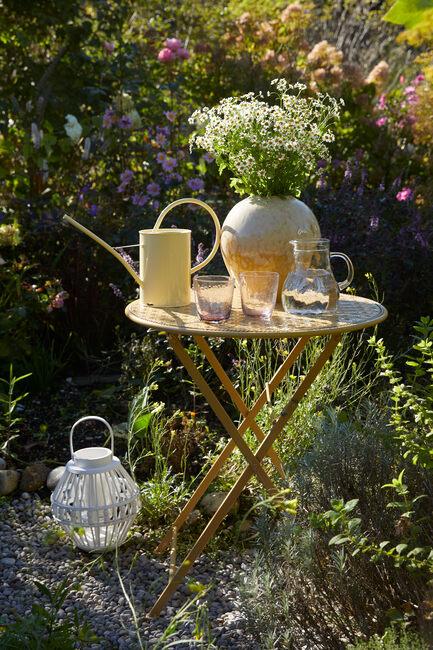 tuin met veel groen en bistrotafel