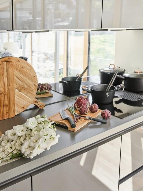 open keuken met beige kastjes en eten op het aanrecht